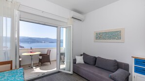 A balcony with a table and chairs, a sofa, and a view of the sea and mountains. - Last-minute offers / Pet-friendly / VERY low low-season prices (Komarna)