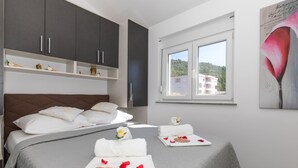 A hotel room with a bed, a window with a view of greenery, and a painting on the wall. - Last-minute offers / Pet-friendly / VERY low low-season prices (Komarna)