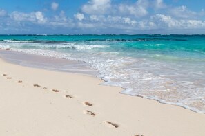 A beach with footprints leading to the water, indicating a path for visitors. - OceanWaves, A Vacation to Remember!A 1minute walk to private gazebo and beach. (Governor's Harbour)
