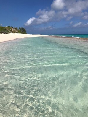 A beach with clear turquoise water and white sand.