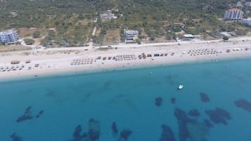 En privat strand, liggestole, parasoller, volleyball
