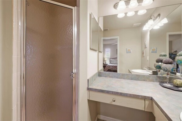 Un baño con un espejo grande, un lavamanos y un mueble tocador con un cajón.