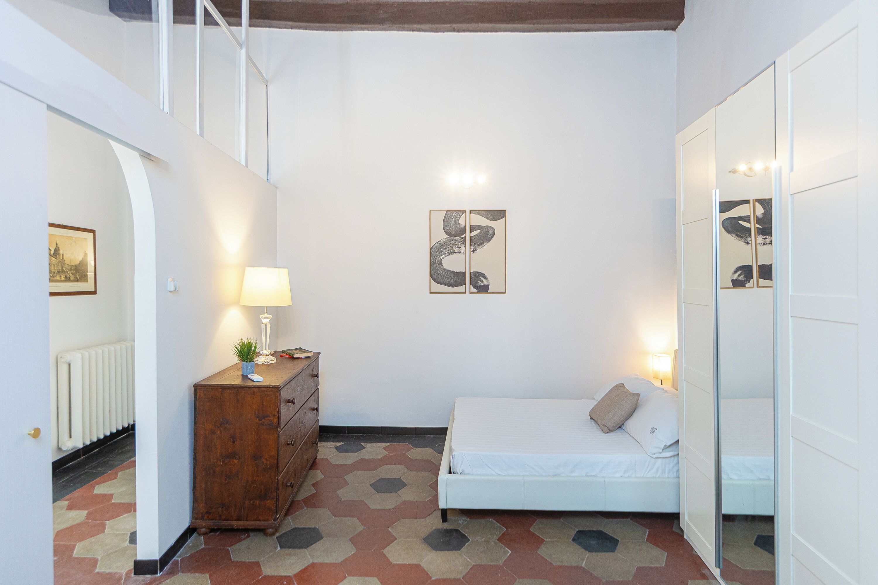 Un dormitorio con cama, cómoda y obra de arte en la pared.