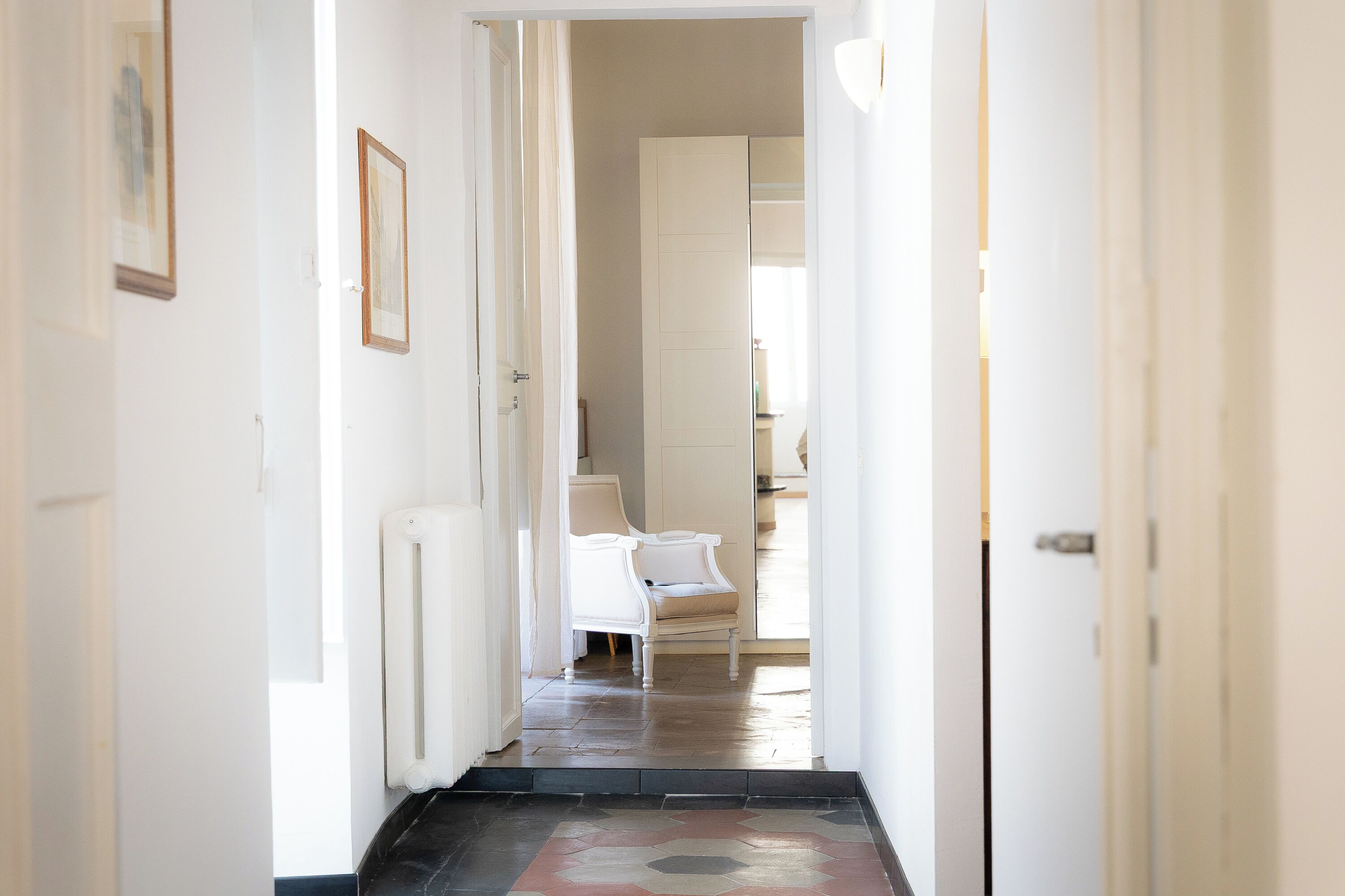 Un couloir avec une chaise et un radiateur.