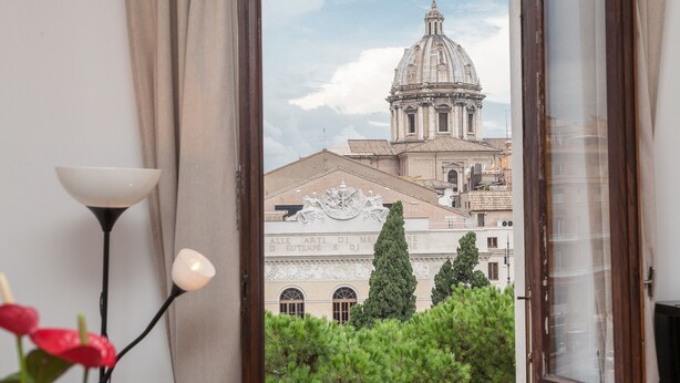A view of a historic building with a dome and classical architecture through a window.