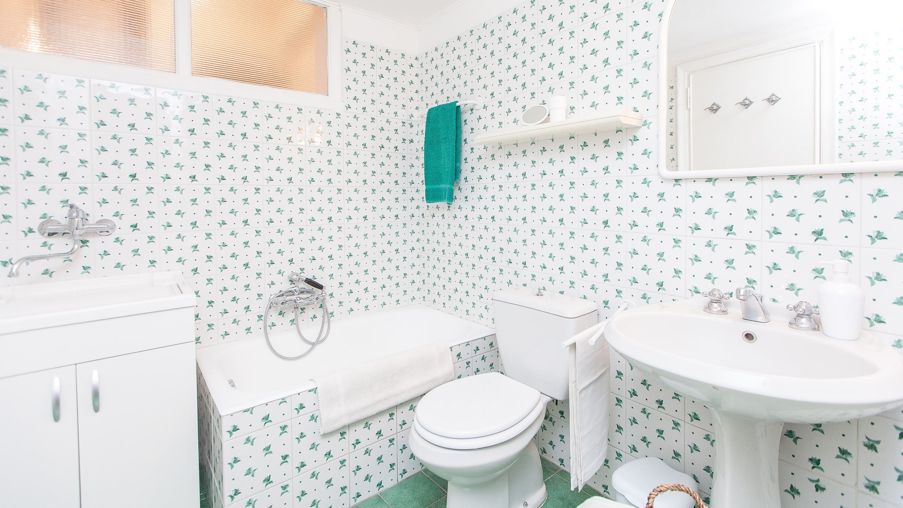 A bathroom with a toilet, sink, and shower.