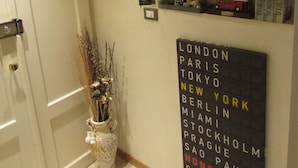 A hallway with a wall-mounted sign listing cities like London, Paris, Tokyo, and New York. - Area39 (Trieste)