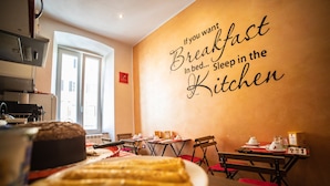 A breakfast setting with tables, chairs, and a wall with a motivational quote. - Area39 (Trieste)