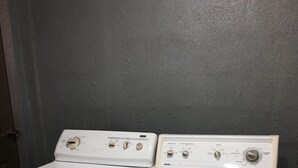 A front-loading washer and dryer unit with a built-in sink. - Island Vibes Suites (Port of Spain)