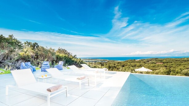 A poolside area with lounge chairs and a view of the sea. - Villa Athena - Villa near the Sea with pool on Corfu Island, Greece (Peritheia)