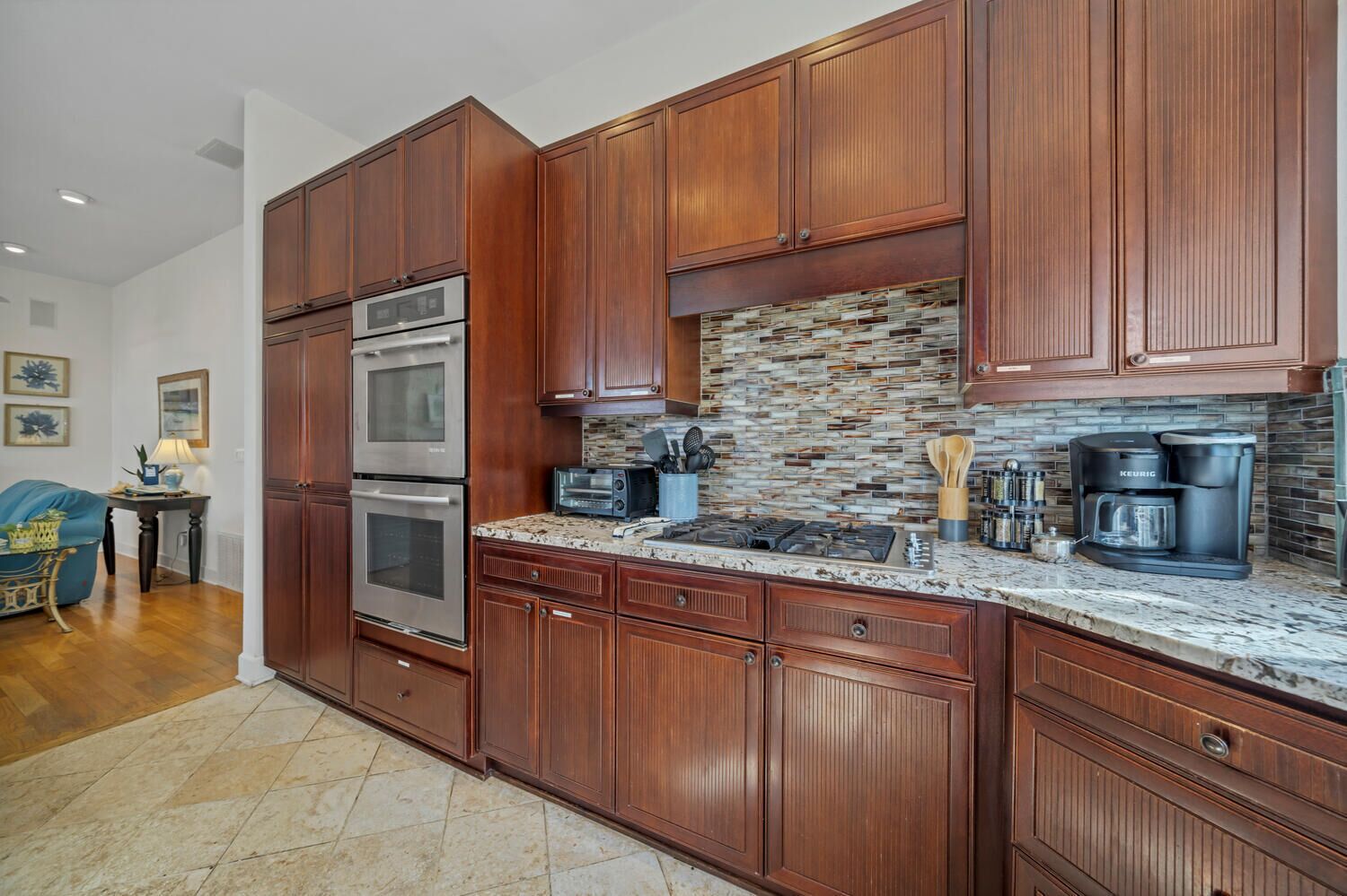 A kitchen with wooden cabinets, a stone backsplash, and stainless steel appliances.
