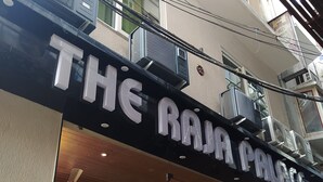 A building with a sign reading "THE RAJA PALACE".