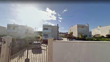 A residential area with modern buildings, a gated entrance, and a clear sky.