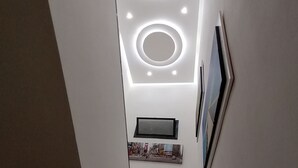 A staircase with a modern design, featuring circular light fixtures on the ceiling and a framed picture on the wall. - Maison Rinaldi (Bari)