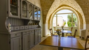 Una cocina con un arco de piedra, armarios de madera y una mesa de comedor con sillas.