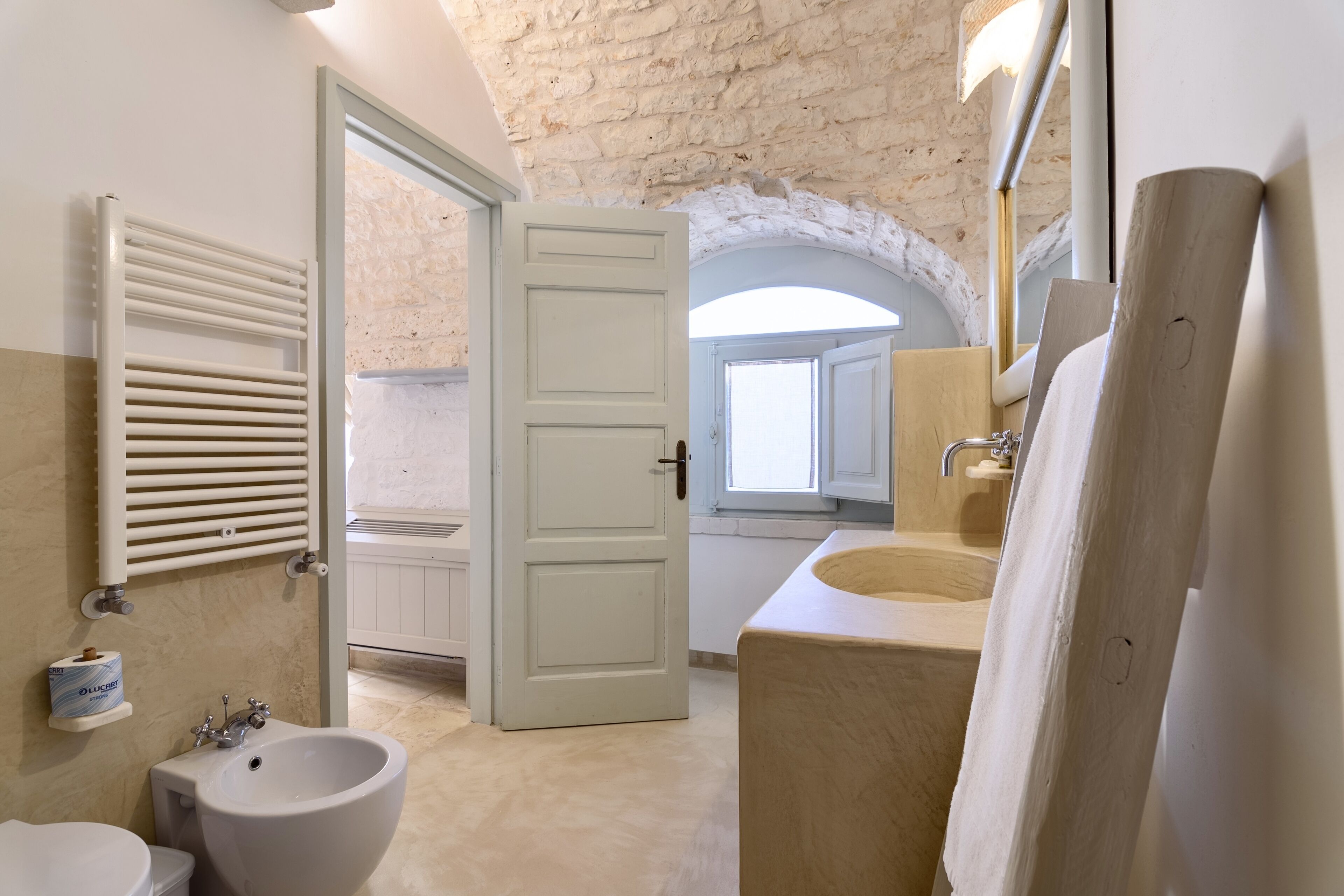 A bathroom with a white bathtub, a sink, and a bidet.