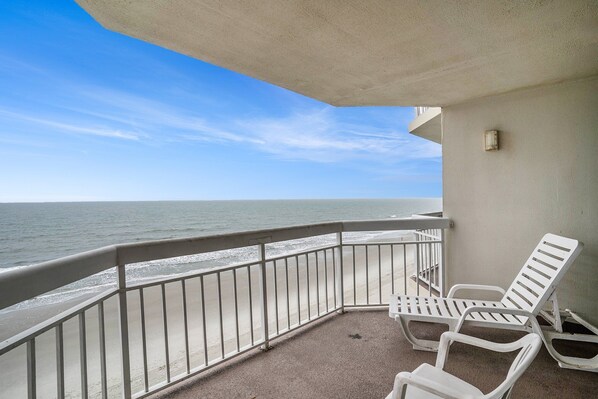 A balcony with white chairs overlooking the ocean. - 0610 Waters Edge Resort 1 Bedroom Condo by RedAwning (Murrells Inlet)