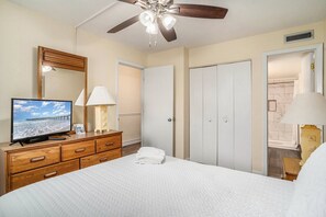 A bedroom with a bed, a dresser, a television, a ceiling fan, and a bathroom door. - 0610 Waters Edge Resort 1 Bedroom Condo by RedAwning (Murrells Inlet)