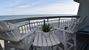 A balcony with white chairs and a table, overlooking the ocean. - 0407 Waters Edge Resort 1 Bedroom Condo by RedAwning (Murrells Inlet)
