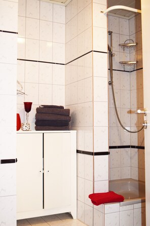 Een haardroger, handdoeken, zeep, toiletpapier
