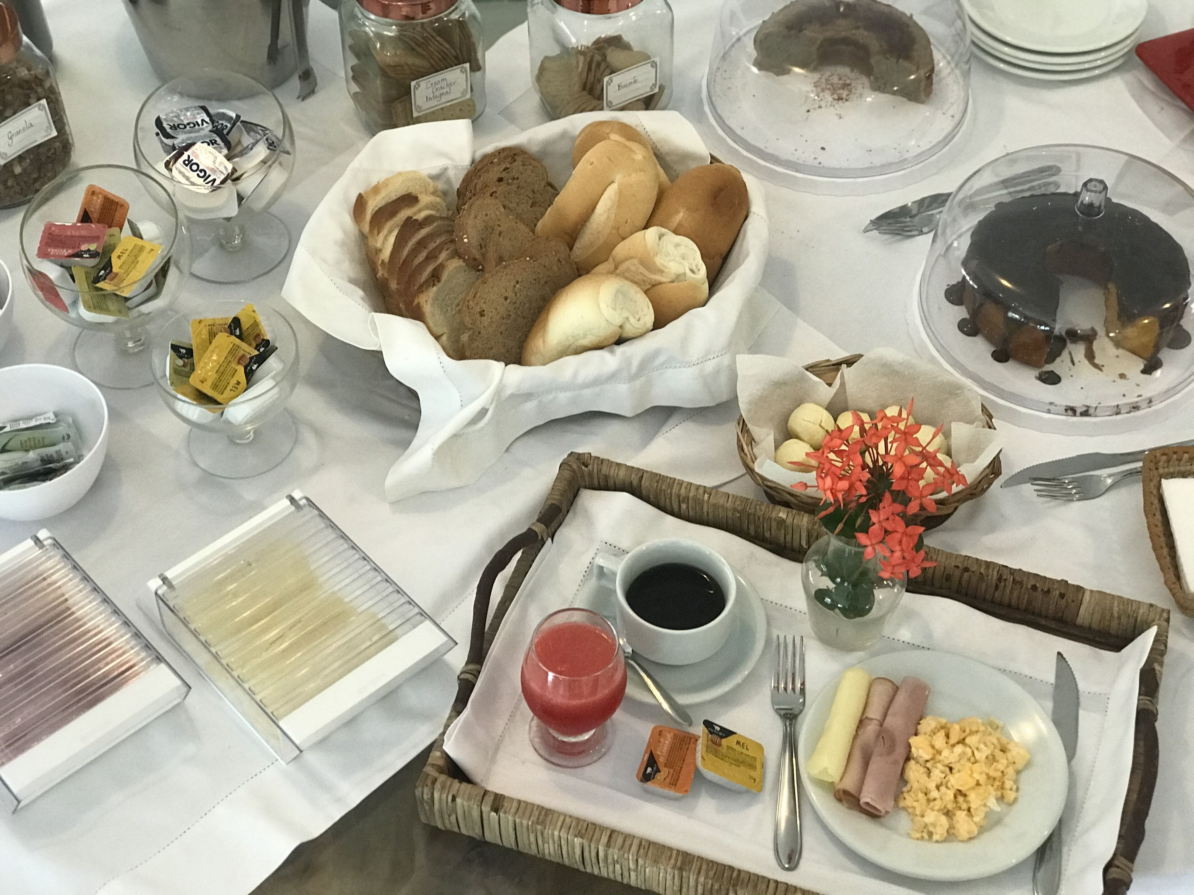 Un bufé de desayuno con diversos alimentos, como pan, bollería y una exposición de frutas.