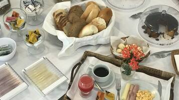 Un bufé de desayuno con diversos alimentos, como pan, bollería y una exposición de frutas.