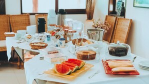 A breakfast buffet with various food items and beverages on a table. - Pousada Oceano (Ipojuca)
