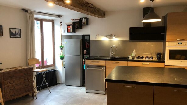 Una cocina con refrigerador, estufa, lavaplatos y gabinetes de madera.