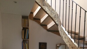 Una escalera con barandillas de madera y una estantería llena de libros.