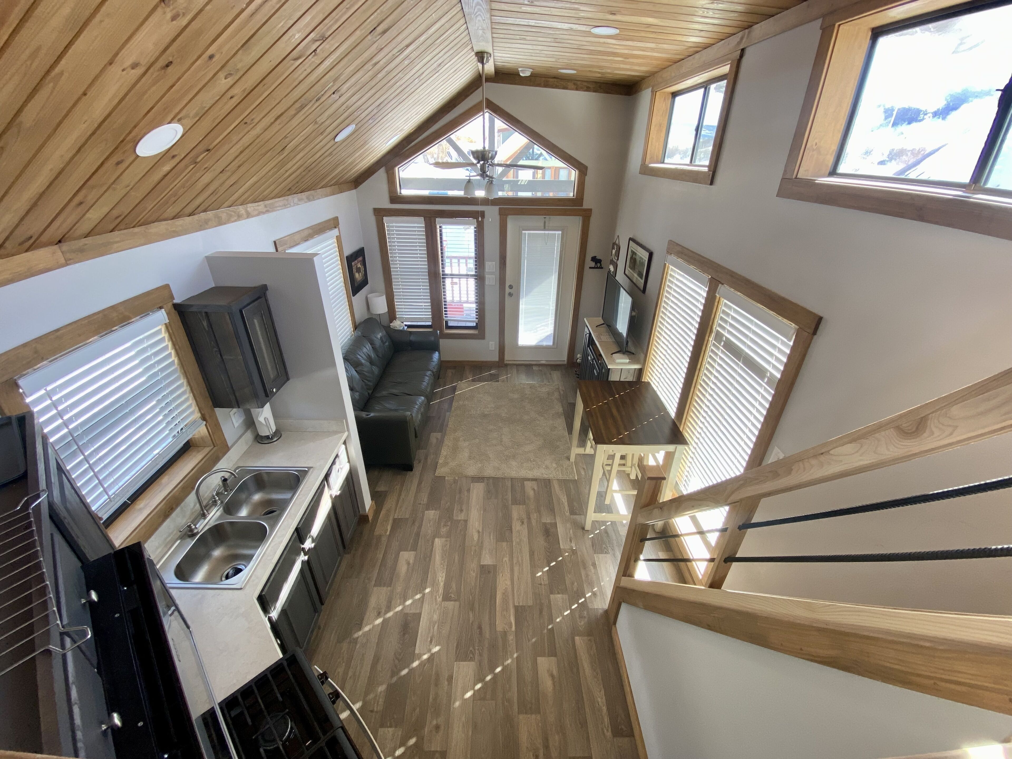 Une cuisine spacieuse de style loft, comprenant un coin repas, un canapé et un escalier menant à un niveau supérieur.