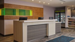 Una recepción de hotel con diseño moderno, un minibar y una estación de bebidas de autoservicio.