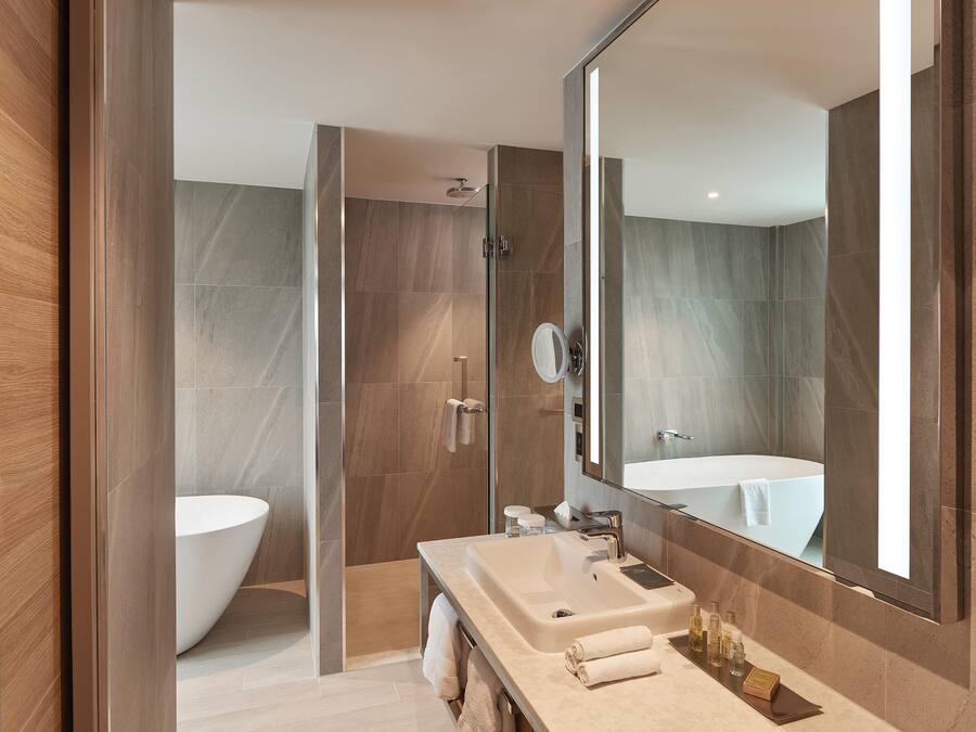 Ein modernes Badezimmer mit einer freistehenden Badewanne, einem großen Spiegel und einem Waschtisch.