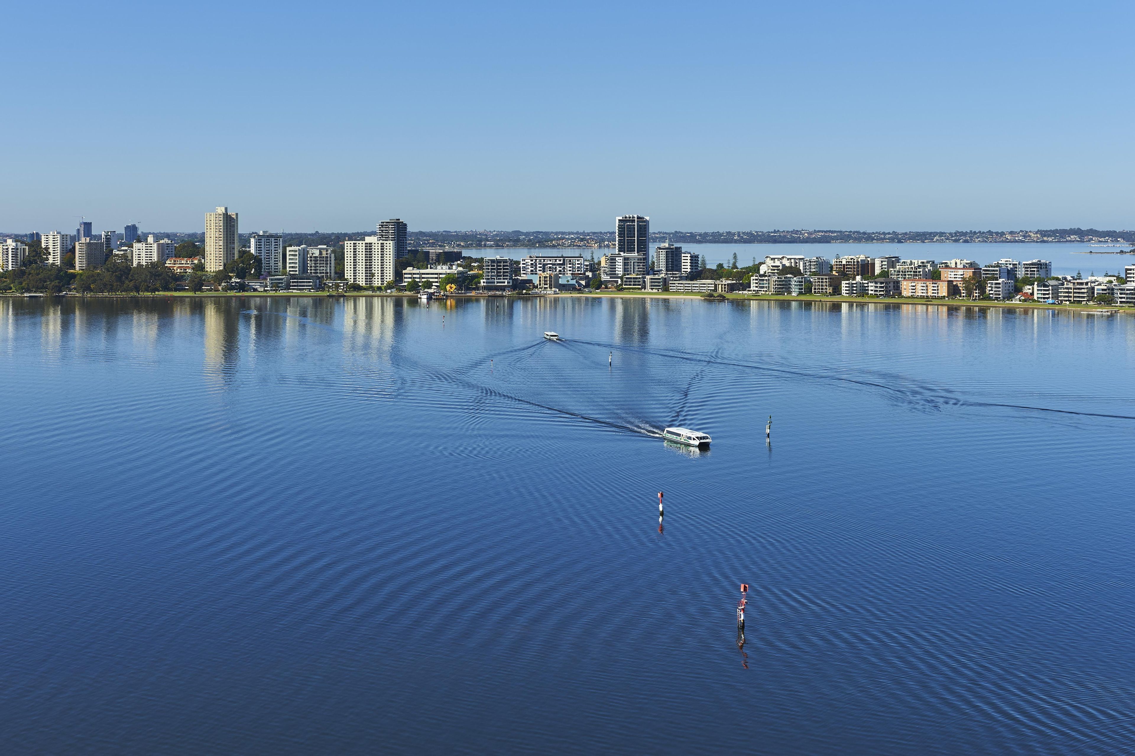 Una masa de agua tranquila con un horizonte urbano al fondo.