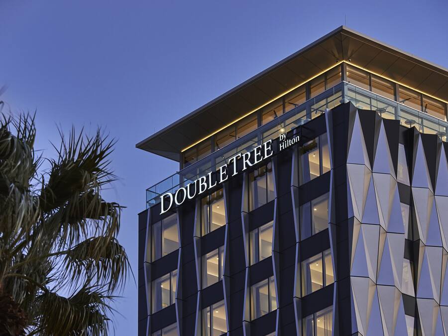 A modern hotel building with the name "DOUBLE TREE by Hilton" prominently displayed.
