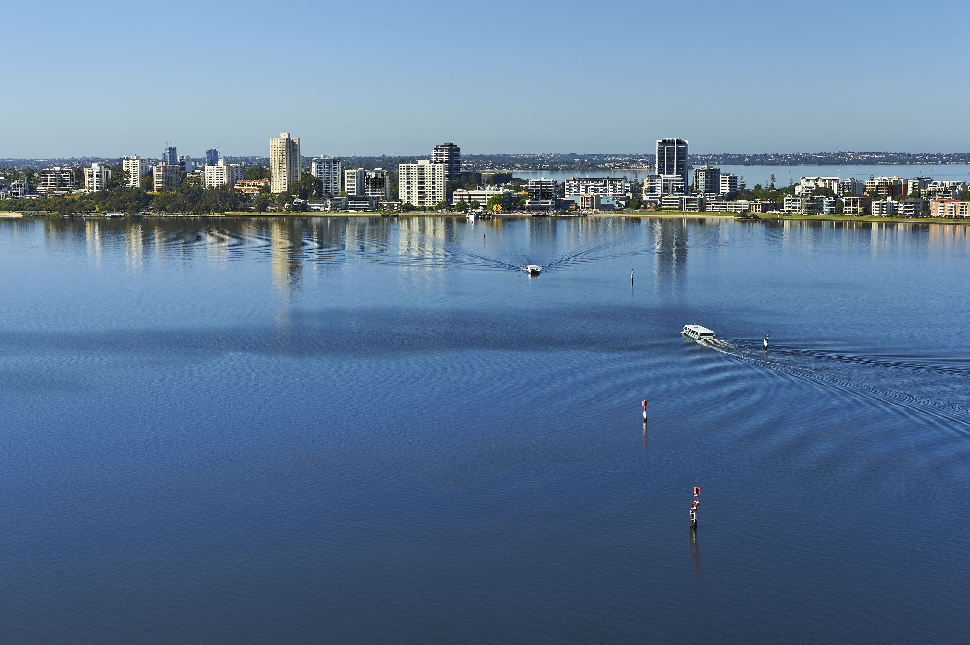 Un lac paisible, avec la silhouette d’une ville en arrière-plan.