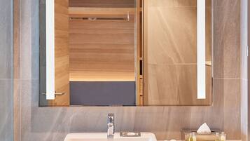 Un baño moderno con un espejo grande, un lavabo y toallas ordenadas.