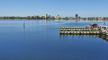 Vista al agua con un muelle y el horizonte de la ciudad al fondo.