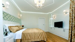 A bedroom with a bed, a television, a dresser, and a mirror. - Comfortable apartment in a new house (Kyiv)