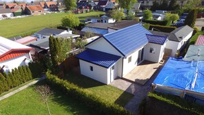A residential area with houses featuring solar panels, a well-maintained lawn, and a clear sky. - Holiday home De Wickinger with your own Steiger angler are welcome! (Wervershoof)
