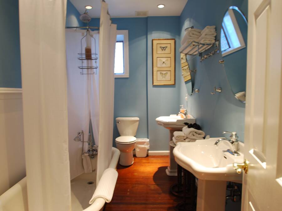 A bathroom with a bathtub, toilet, sink, and shower.