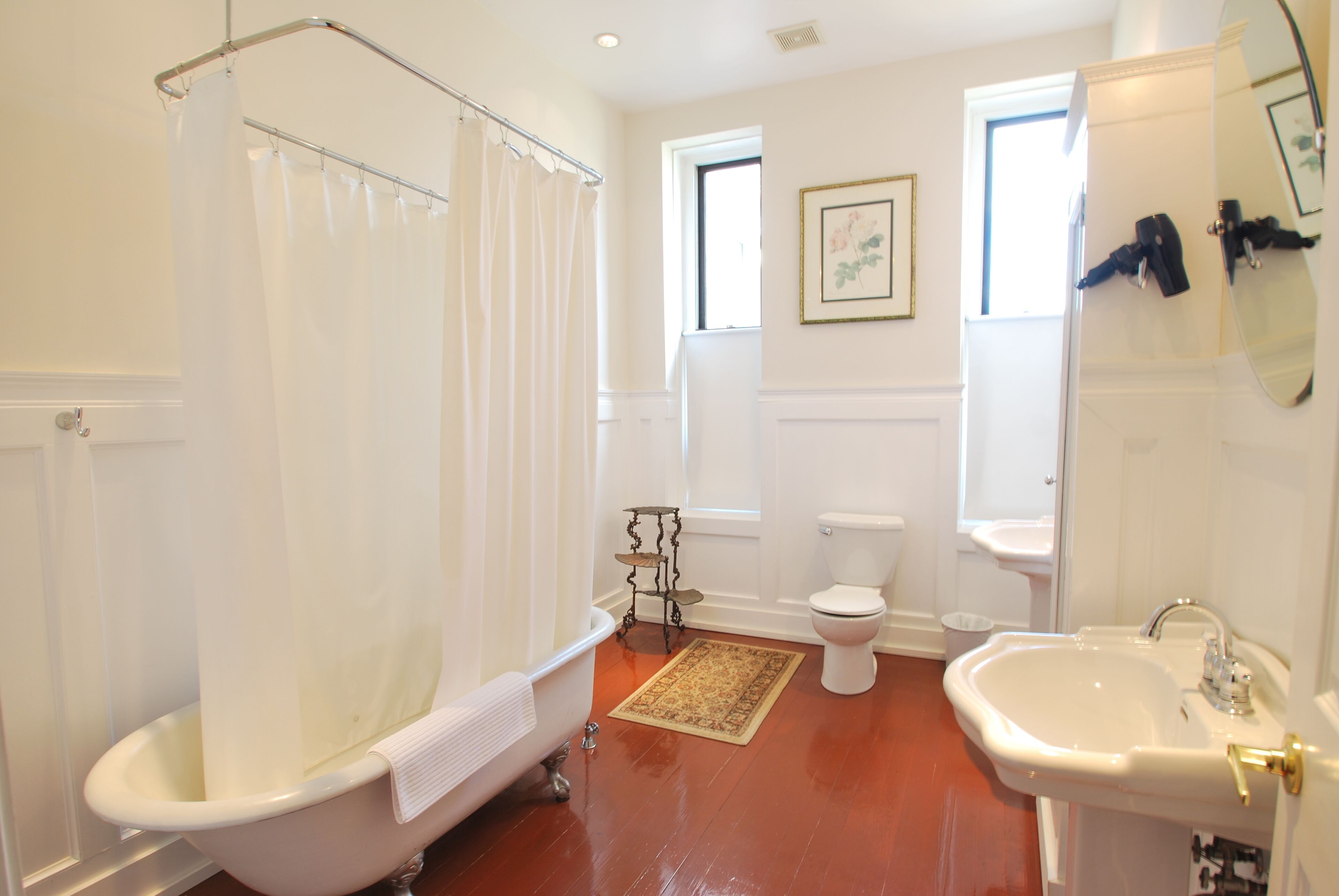 Ein Badezimmer mit Badewanne, Toilette, Waschbecken und Spiegel.