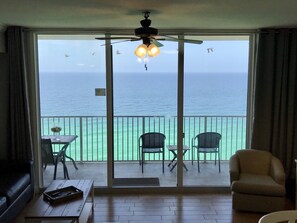 A room with a sliding glass door leading to a balcony with a view of the ocean. - Sunset Shores. Amazing Views (Panama City Beach)
