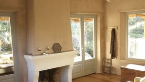 A spacious living area with a fireplace, a sofa, and a dining table.