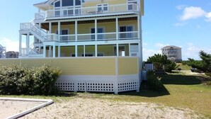 A multi-story building with balconies, a staircase, and a grassy area in front. - Spectacular OCEAN and SOUND VIEW Private Pool (Salvo)