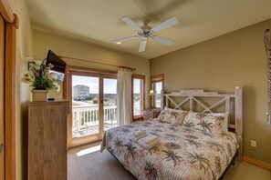 A bedroom with a bed, a ceiling fan, a dresser, and a view of the outside. - Spectacular OCEAN and SOUND VIEW ,Elevator, Private Pool, Hot Tub, Lux Retreat (Salvo)