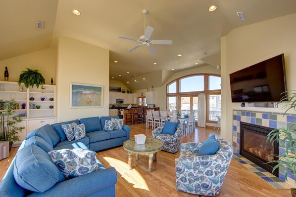 A spacious living room with a large sectional sofa, patterned armchairs, a glass coffee table, and a fireplace. - Spectacular OCEAN and SOUND VIEW Private Pool (Salvo)