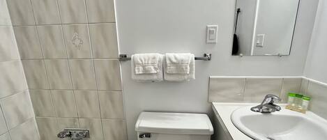 Un baño con bañera, inodoro y lavabo.