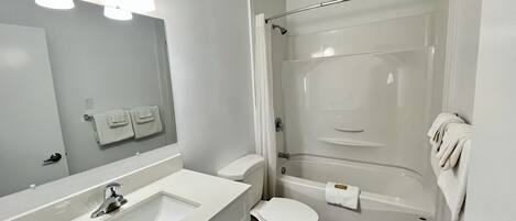 Un baño con lavamanos, inodoro y ducha.