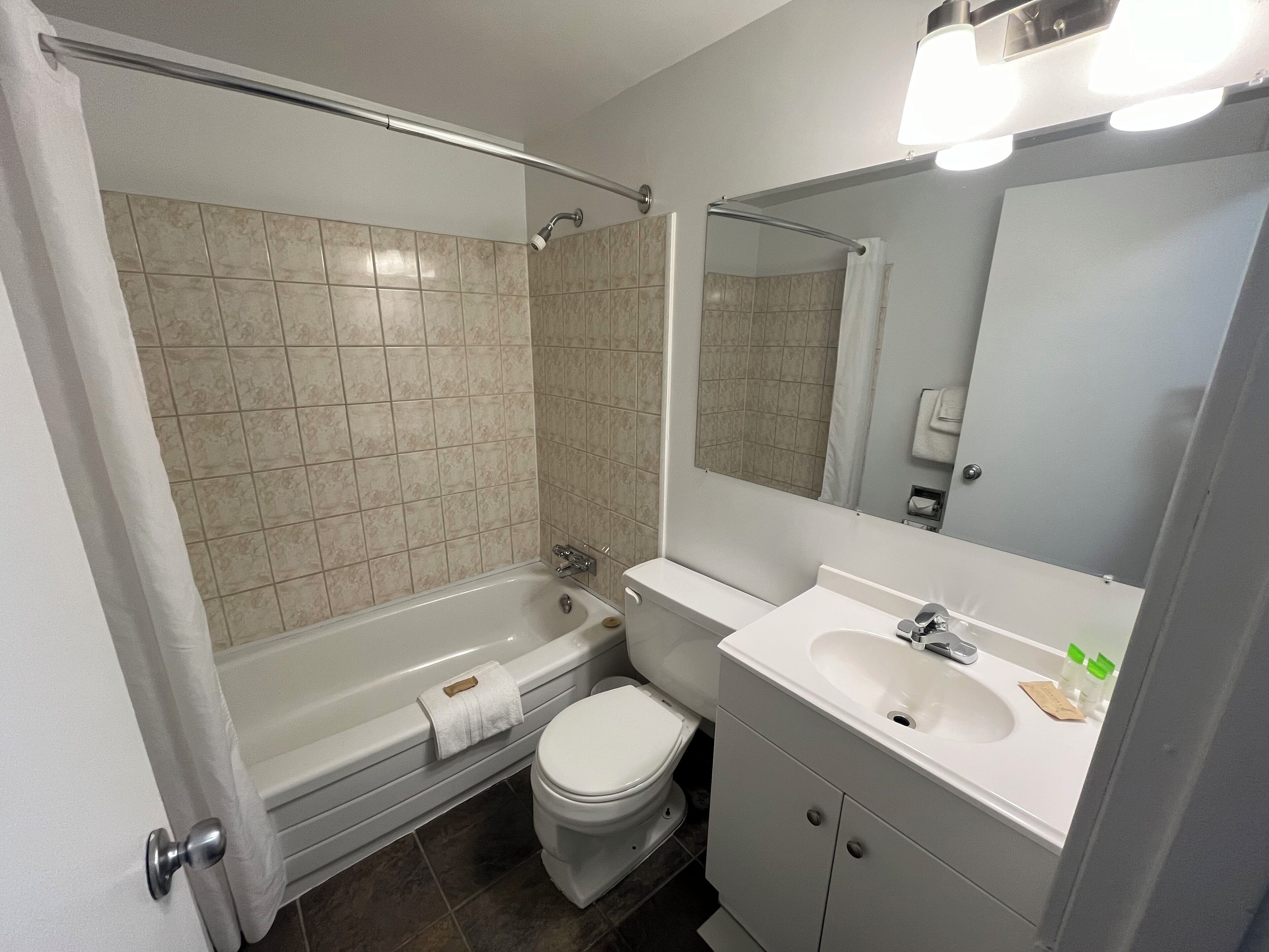 A modern bathroom with a bathtub, toilet, and sink.