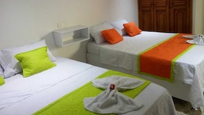 Two single beds with white bedding and orange pillows, a wooden wardrobe, and a white shelf unit. - Hotel Casa Garces Cartagena (Cartagena)